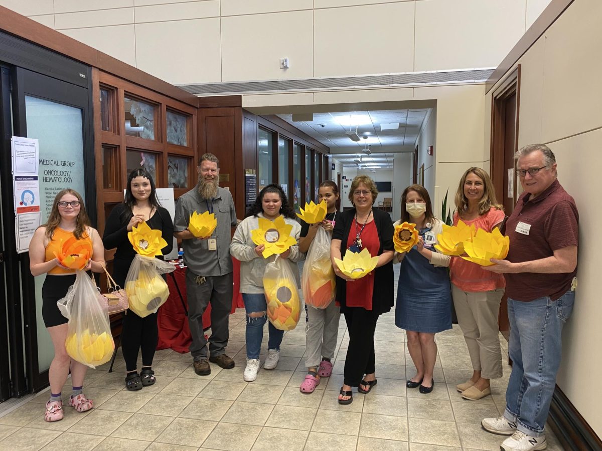 ACE students and staff inside Praxair presenting the sunflowers to Amy DePaolo.